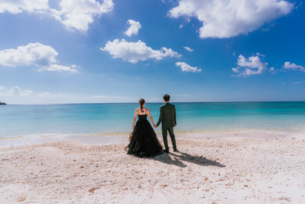 沖縄の青いビーチを眺めている夫婦