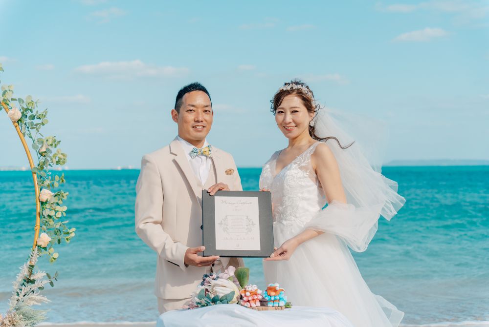 夫婦でオリジナル結婚証明書をもって笑顔