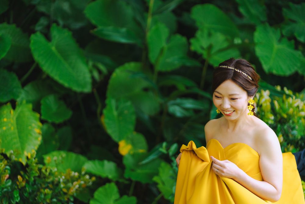 雨の日ウェディング撮影_緑の前で鮮やかなイエローのドレスの新婦