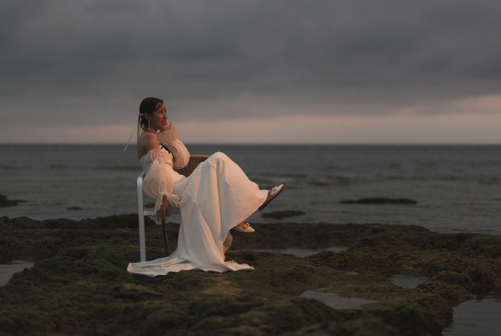 サンセット時‗ビーチで椅子に座りポーズを決めるホワイトドレスの花嫁